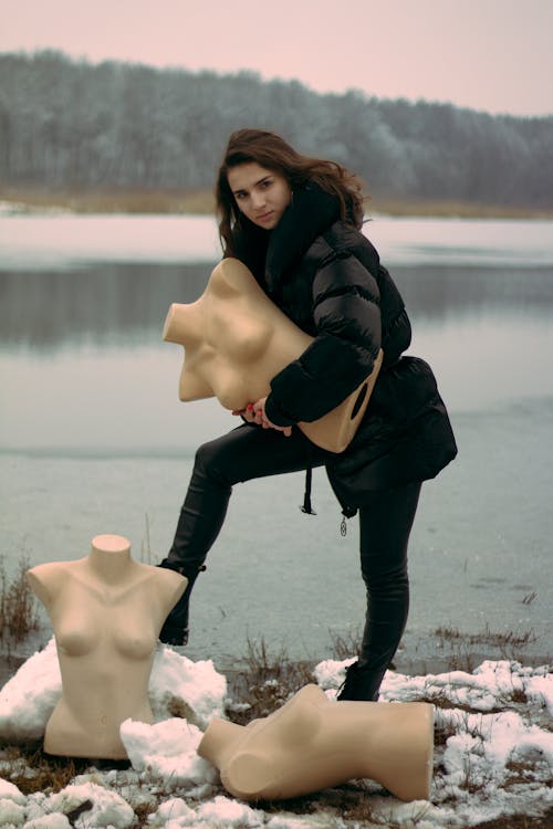 A Woman Posing while Holding a Mannequin