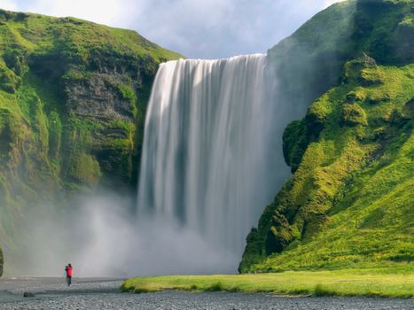 Scenic view of Skógafoss waterfall in Iceland with lush greenery. Perfect for nature lovers.