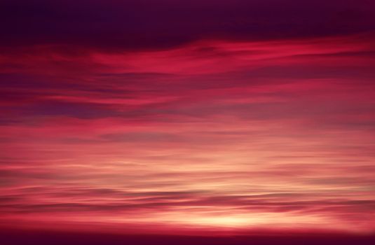 A captivating view of a vibrant sunset with a richly colored sky and layered clouds.