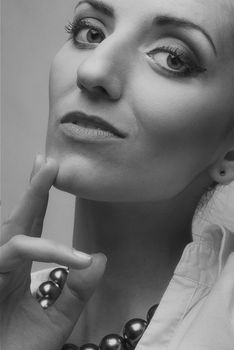 Close-up black-and-white portrait of a sophisticated woman with jewelry.