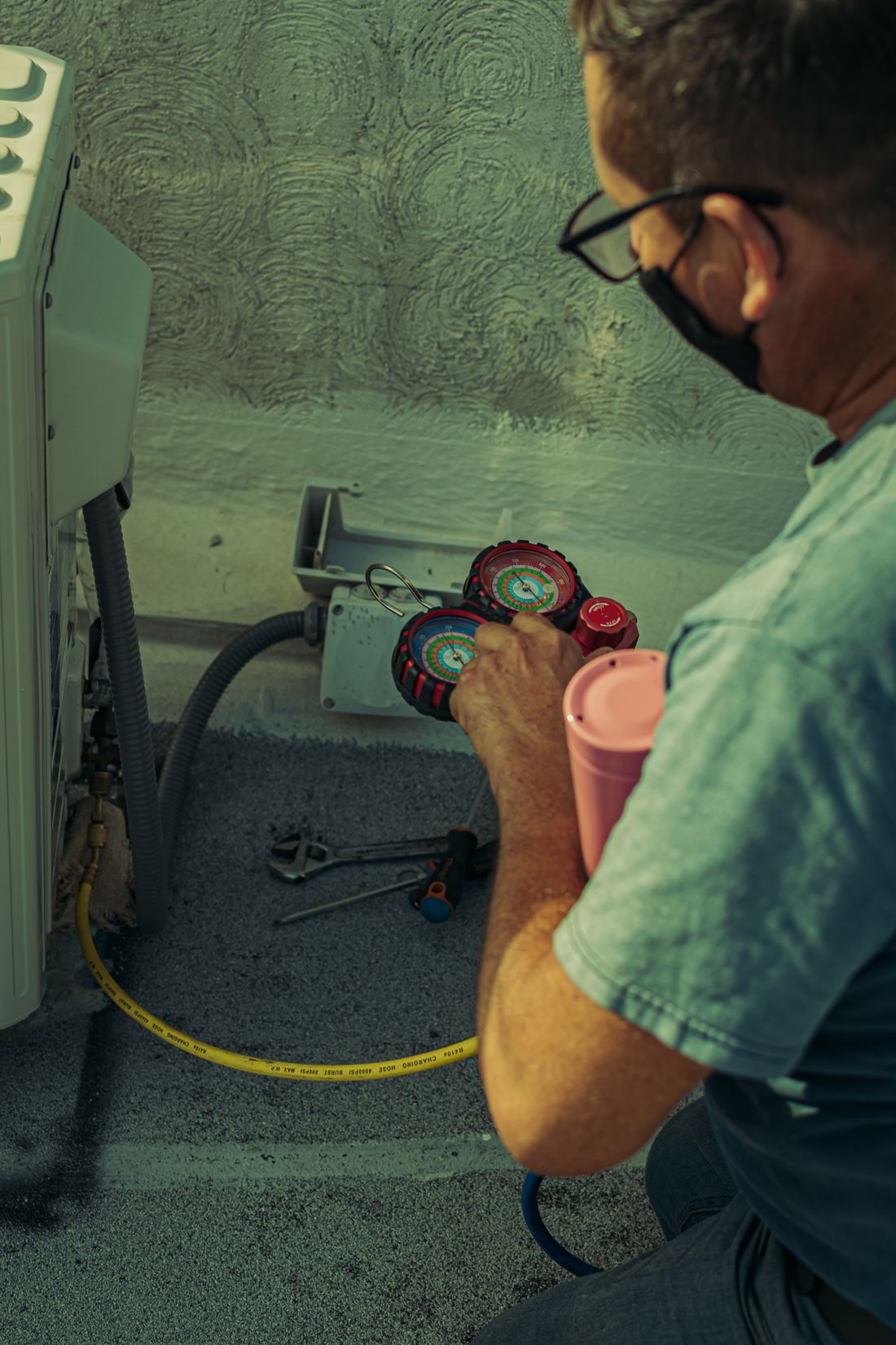 Technician checking and repairing an outdoor HVAC system using diagnostic tools