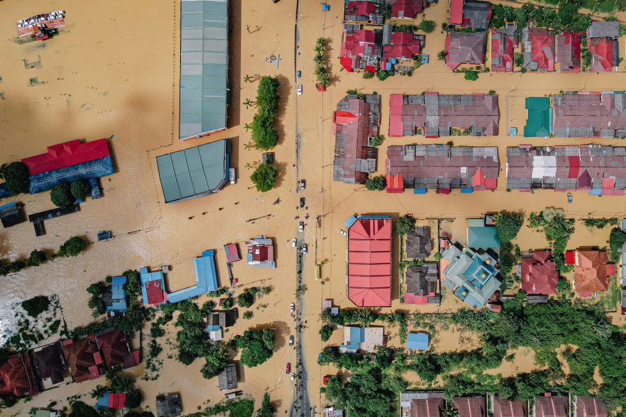 Aerial view of houses and trees surrounded by flood water