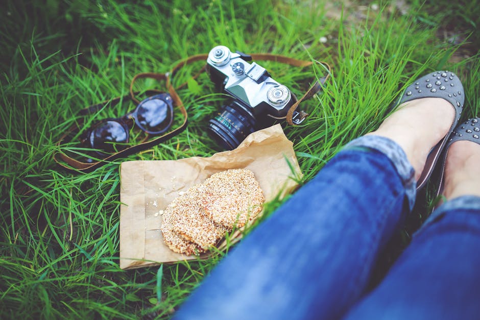 Girl resting on green grass with cookies and camera