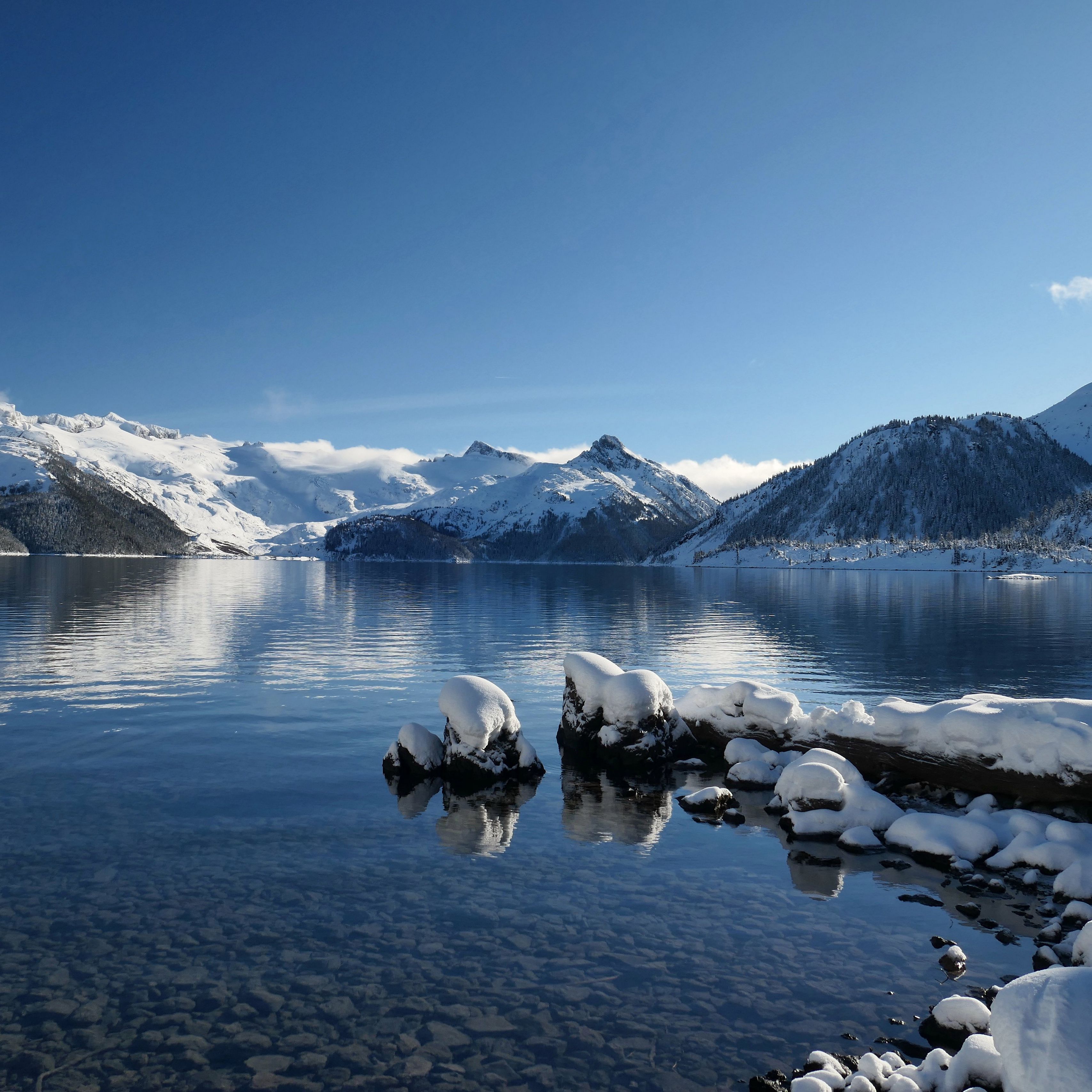 Snowy Mountains Near Lake Under Blue Sky · Free Stock Photo