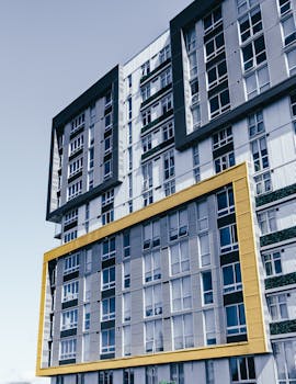 Low-angle view of a modern urban high-rise building facade with geometric design.