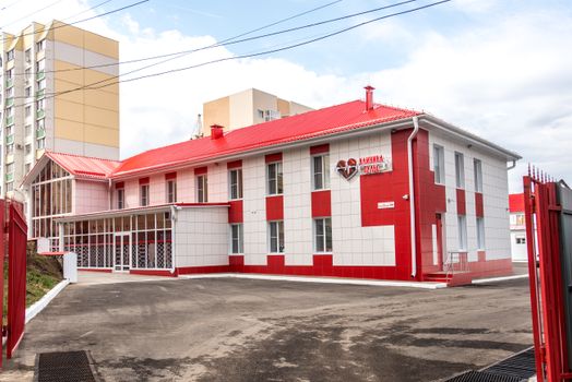 Modern clinic building with red and white facade, showcasing contemporary architecture.