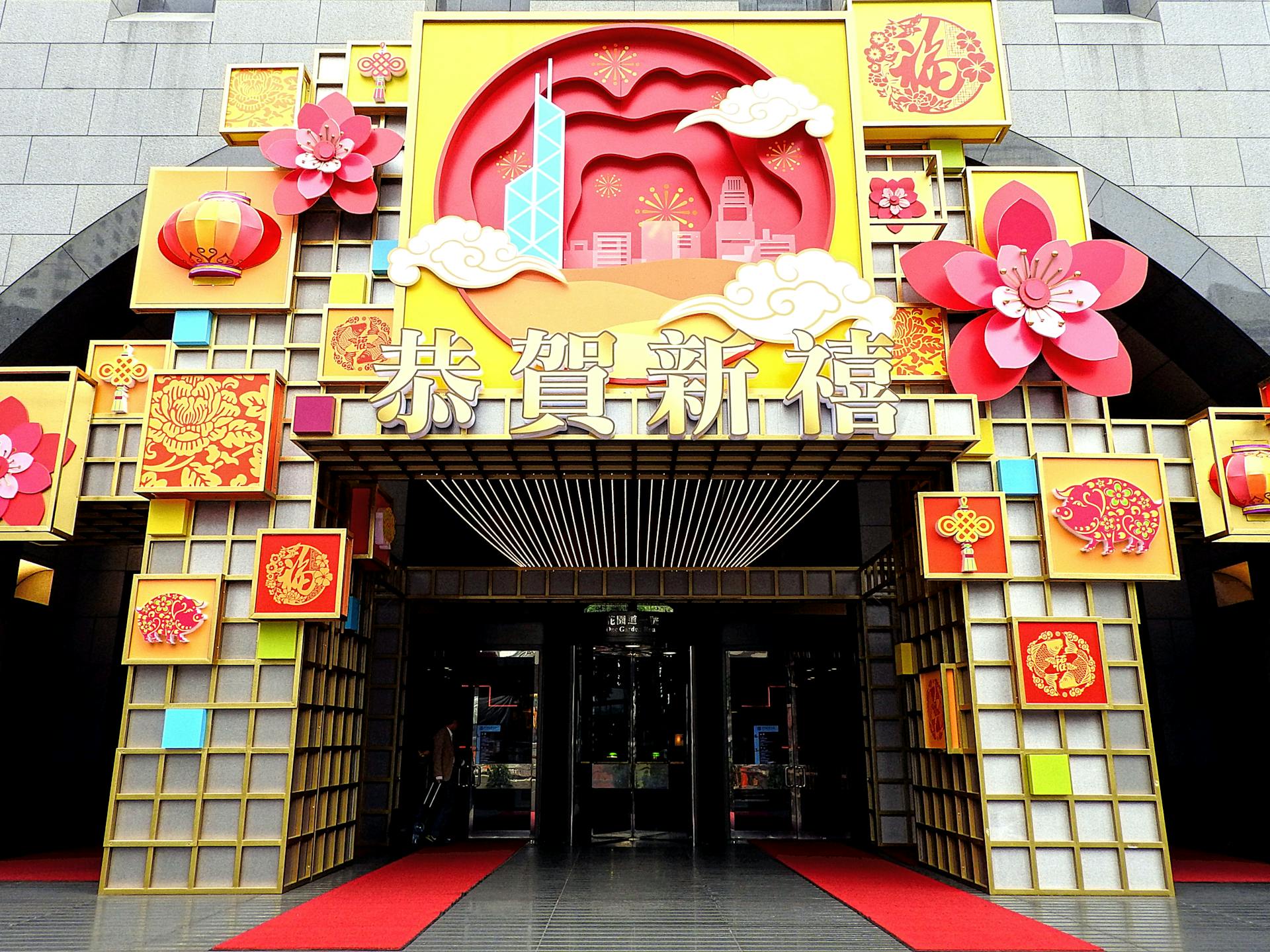 Exterior of colorful Asian building decorated with signboards and hieroglyphs near decorative elements in town street in daylight near entrance on pavement