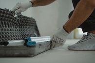 A construction worker organizing tools inside a toolbox on a job site.