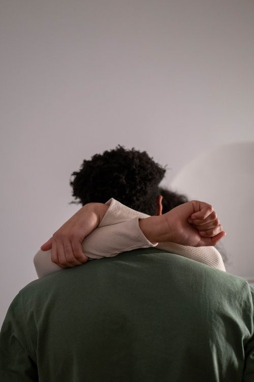 Free A tender moment of a couple embracing from behind, conveying warmth and connection. Stock Photo