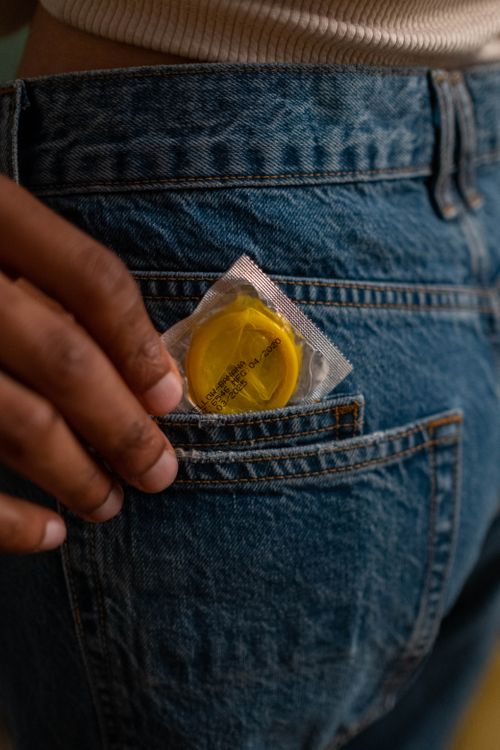 Free Close-up of a condom in a denim jeans pocket, symbolizing safe sex practices. Stock Photo