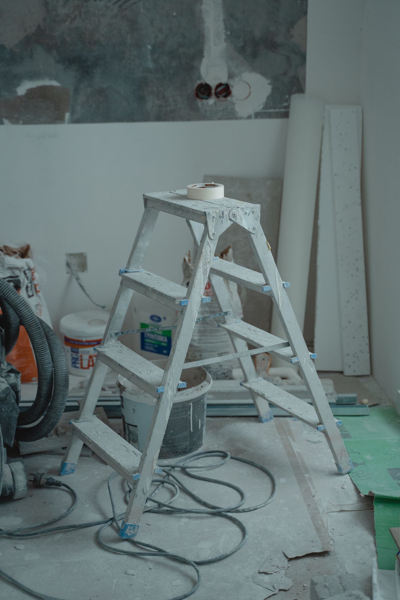 Construction crew in protective gear plastering an interior wall during a renovation