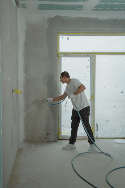 Man in White Dress Shirt and Black Pants Holding a Spray Hose