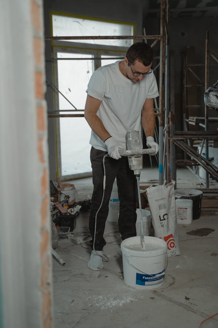 A Man In White Shirt Drilling 