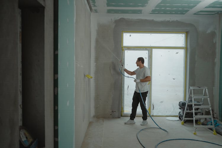 Man In White Dress Shirt And Black Pants Holding A Spray Hose