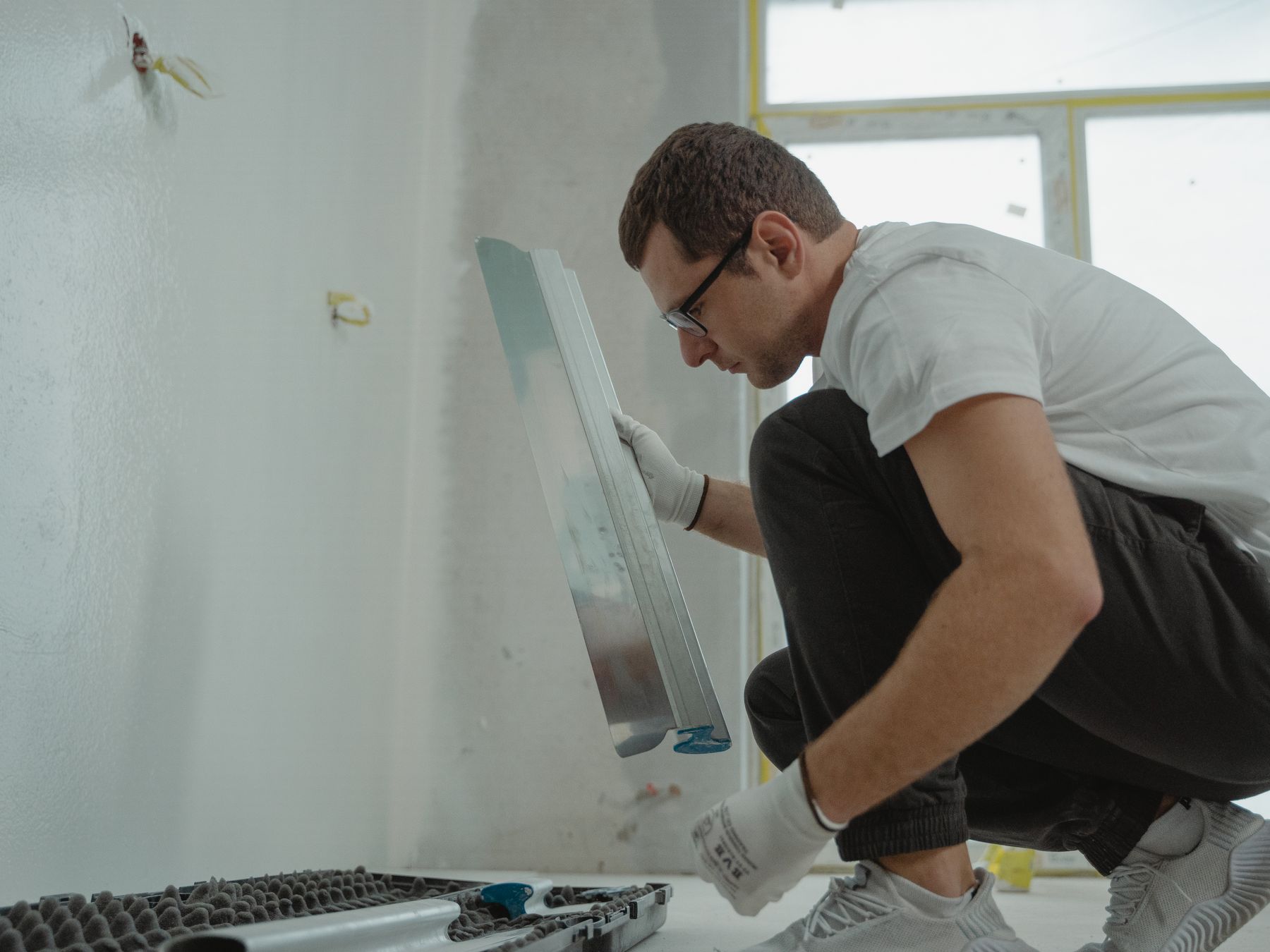 Plasterer skimming a wall smooth with a trowel