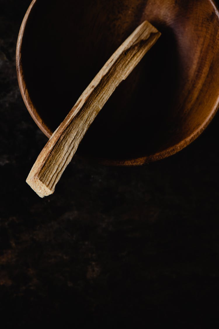 A Piece Of Palo Santo In A Wooden Bowl