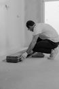 Man in White Shirt and Black Pants Sitting on Floor
