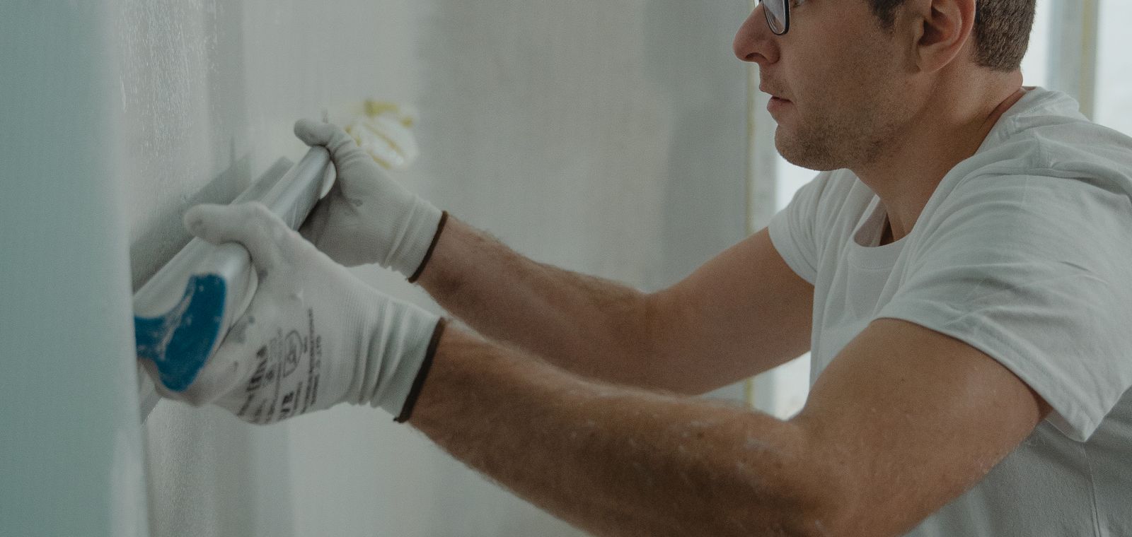 Worker applying drywall compound to a wall