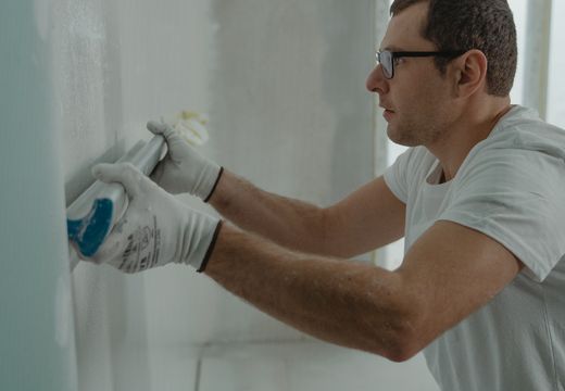Worker applying drywall compound to a wall
