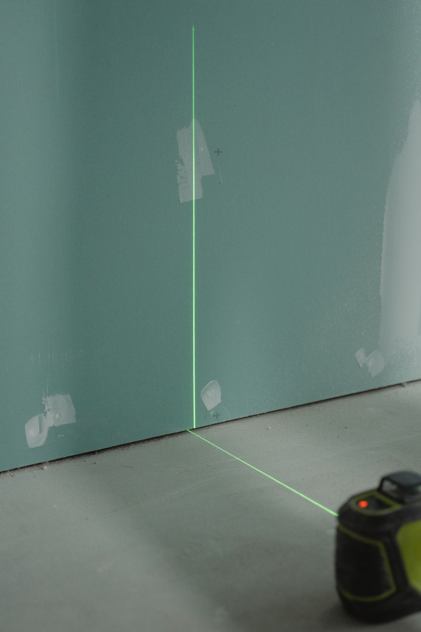 Laser de precisão em parede de obra representando planejamento profissional da gestão de resíduos