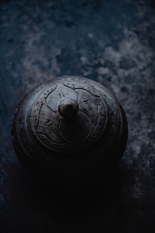 Free A dark artistic photo of a carved wooden lid captured from above. Stock Photo