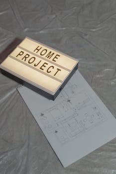 Illuminated home project sign with architectural floor plan on gray background, perfect for construction themes.