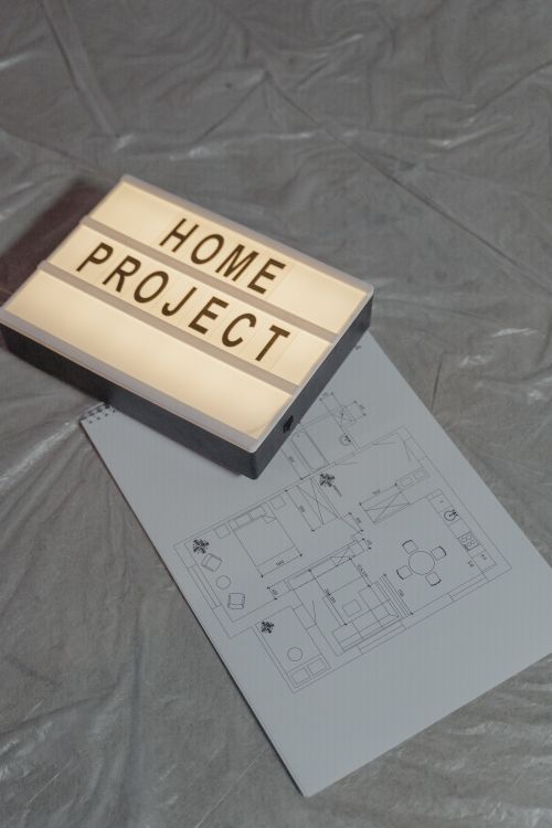 Free Illuminated home project sign with architectural floor plan on gray background, perfect for construction themes. Stock Photo
