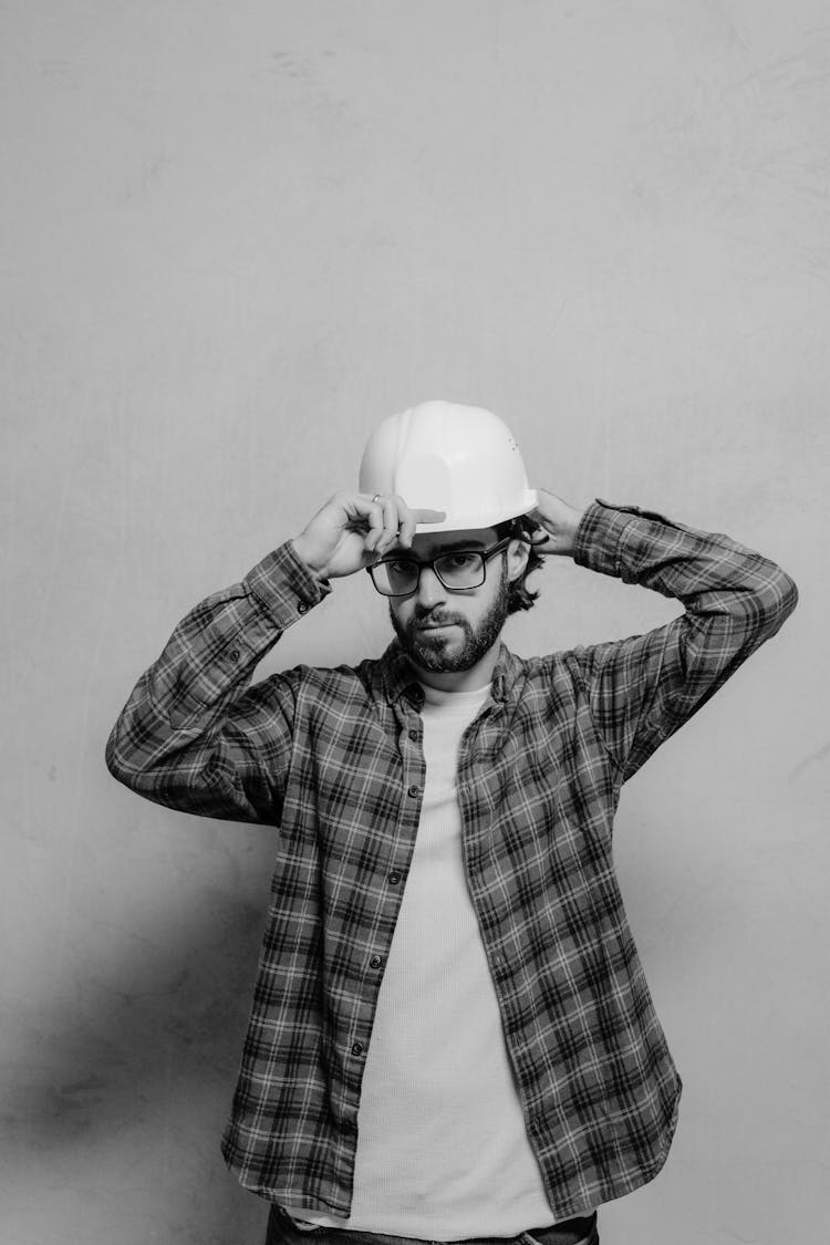 Man In Plaid Dress Shirt Wearing White Hard Hat And Black Eyeglasses