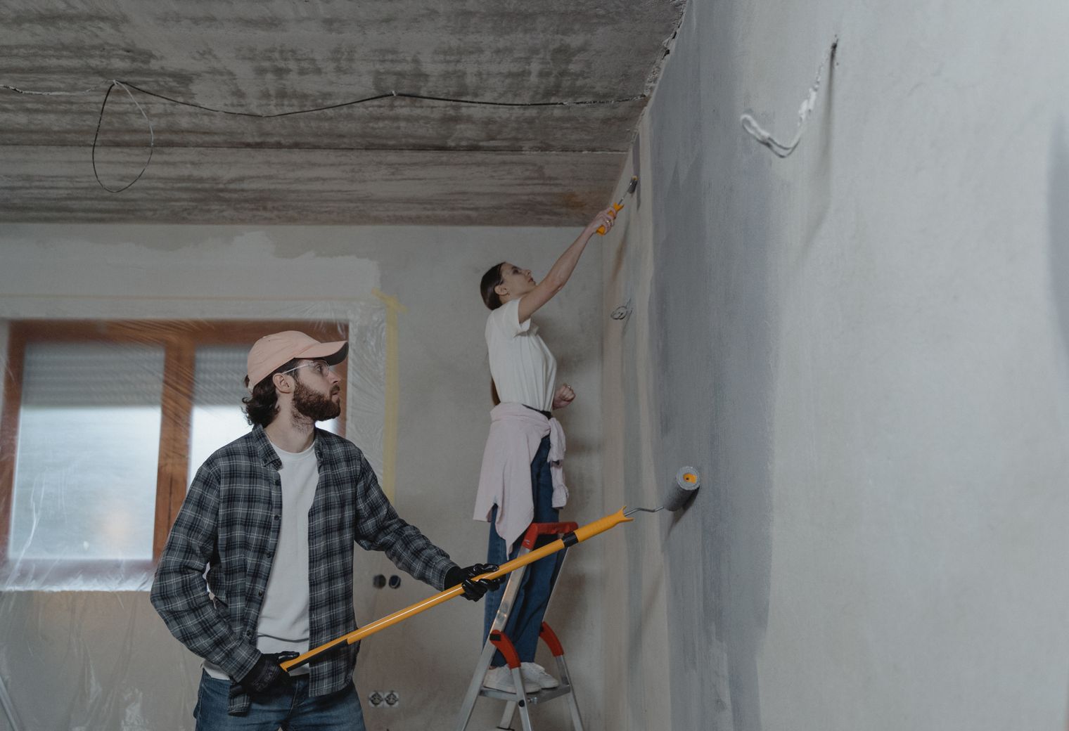 Two decorators painting a room together during a home renovation