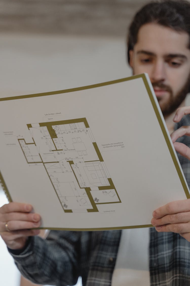 A Man Holding A Floor Plan