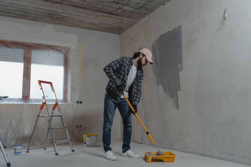 Painter on a stepladder painting a room