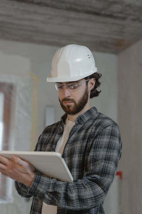 Man in Black and White Plaid Button Up Shirt Wearing White Hard Hat