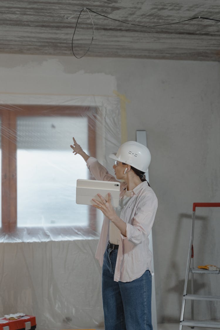 Woman Pointing To The Window While Holding The Ipad