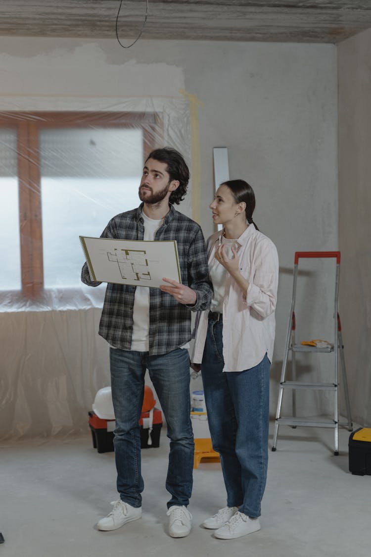 A Couple Looking At A Home Under Construction