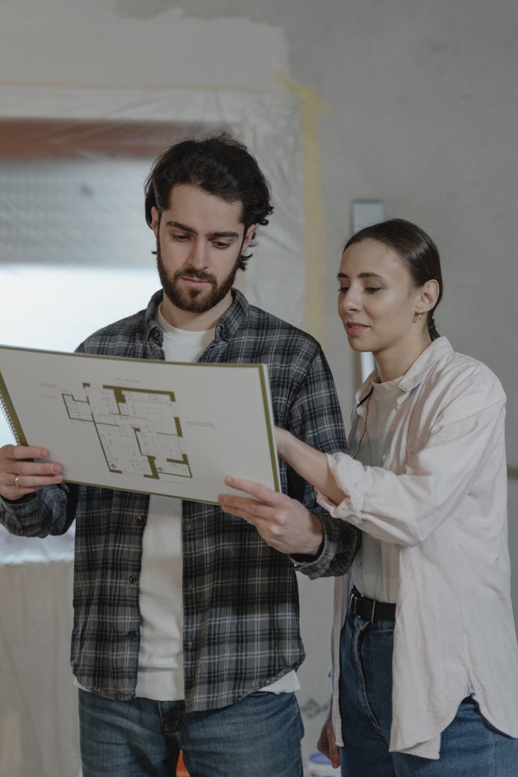 Couple Looking At The Blueprint