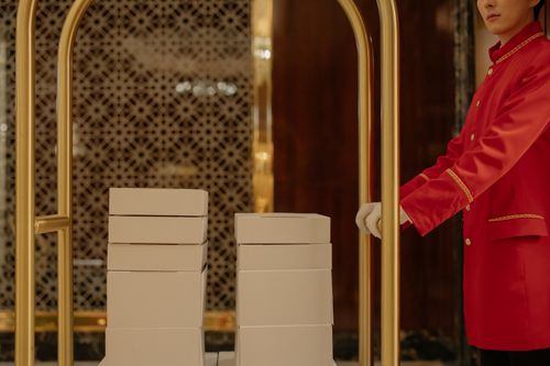 Free Hotel porter in red uniform assisting with luggage cart in a luxury hotel setting. Stock Photo