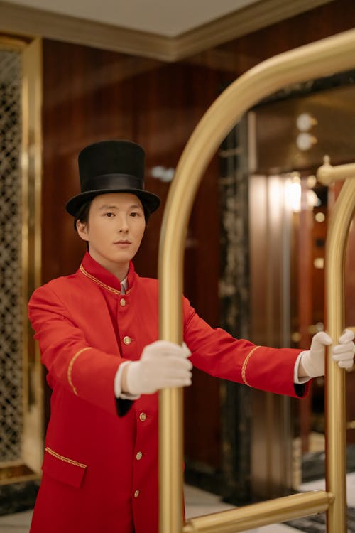 Man in Red Uniform Pushing a Cart