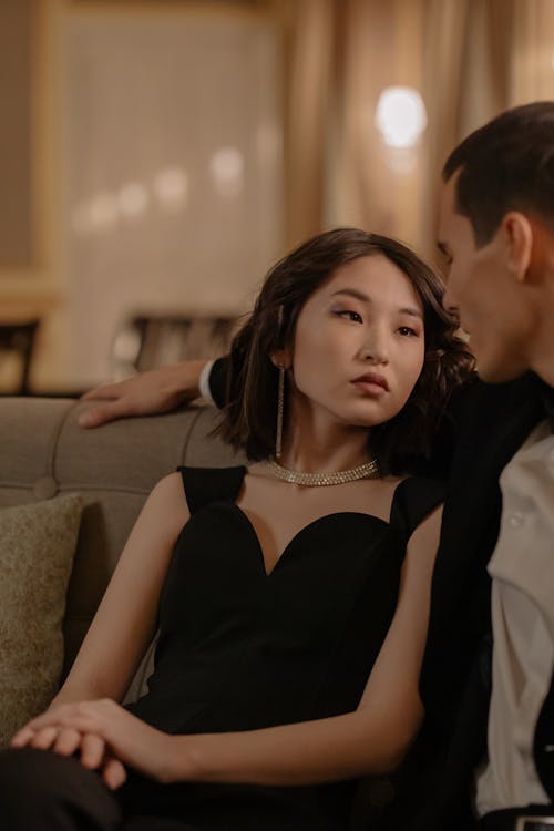 Free Woman in Black Dress Sitting on Couch Looking at the Man  Stock Photo