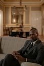 Man in Black Suit Sitting on Couch