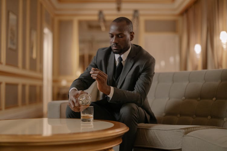 Man Pouring Whiskey On His Glass