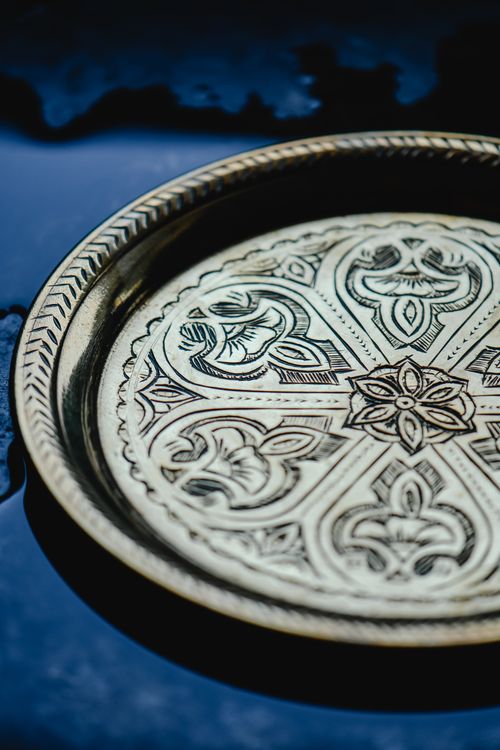 Free Close-up of a decorative brass plate showcasing intricate patterns and design. Stock Photo