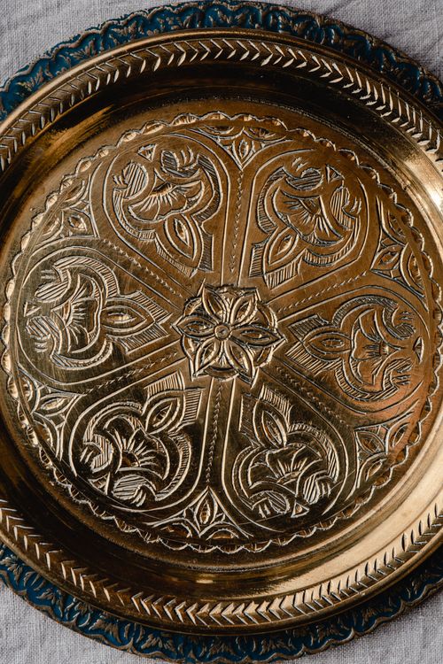Free Close-up of an elegant brass tray with detailed floral carvings, showcasing craftsmanship. Stock Photo