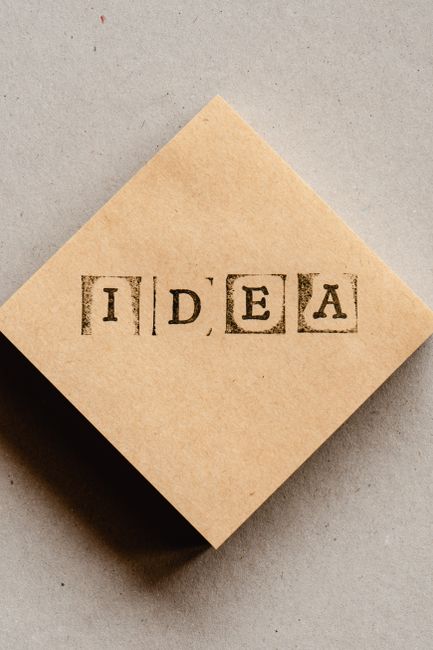 Cardboard piece with 'IDEA' stamped in block letters, symbolizing creativity.