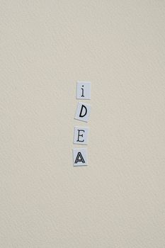 Minimalist display of the word 'IDEA' on a textured wall, emphasizing creativity and design.