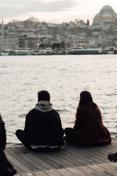 Free Back view of anonymous couple admiring rippled water and mosque with buildings in Istanbul Turkey Stock Photo