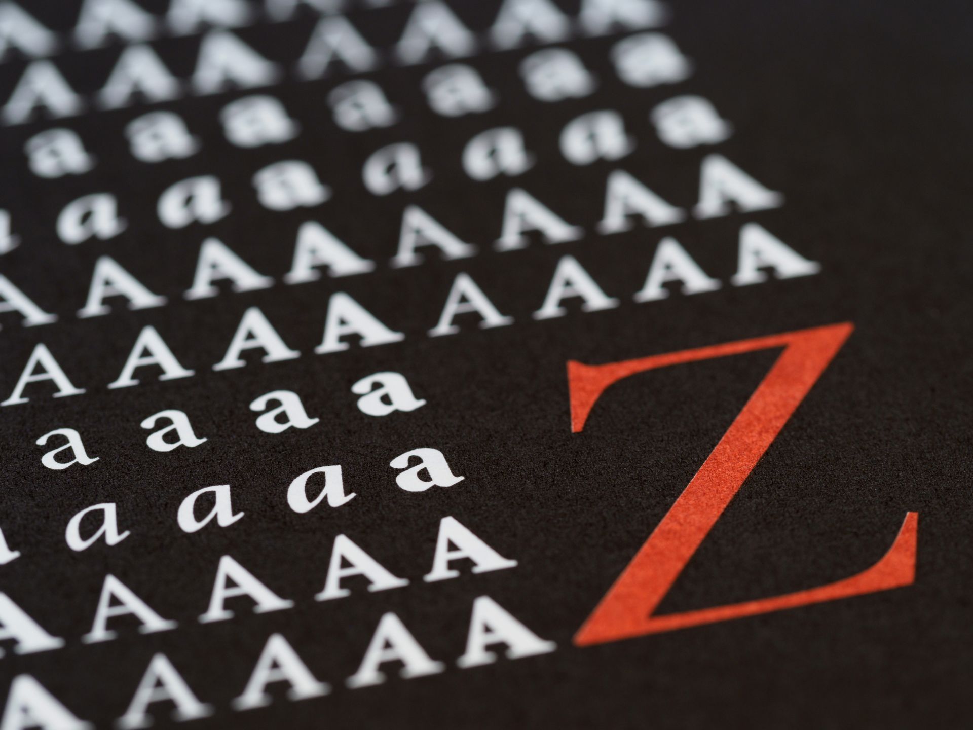Artistic close-up of alphabet letters on black background highlighting typography design.