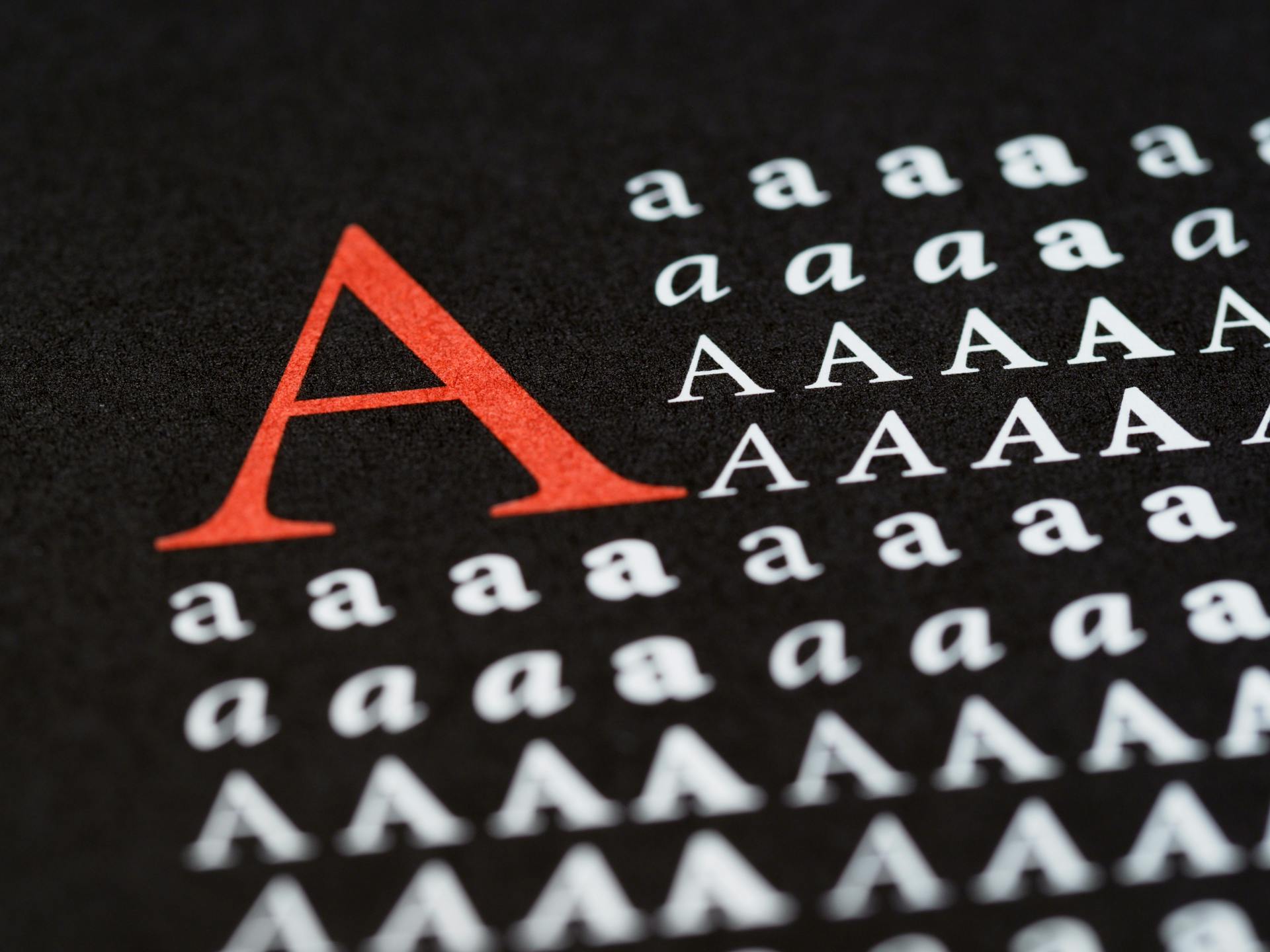 A detailed close-up of different letter A styles and sizes on a black background, highlighting typography and design.