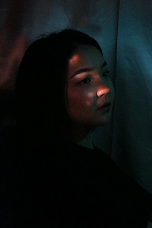 Thoughtful Asian woman in dark room