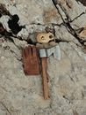 Top view of sharp hatchet with wooden handle and leather glove placed on shabby rocky surface in nature during camping
