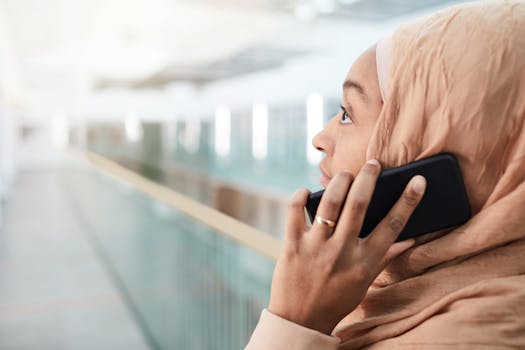 Close-up of a woman wearing a hijab talking on her smartphone indoors.